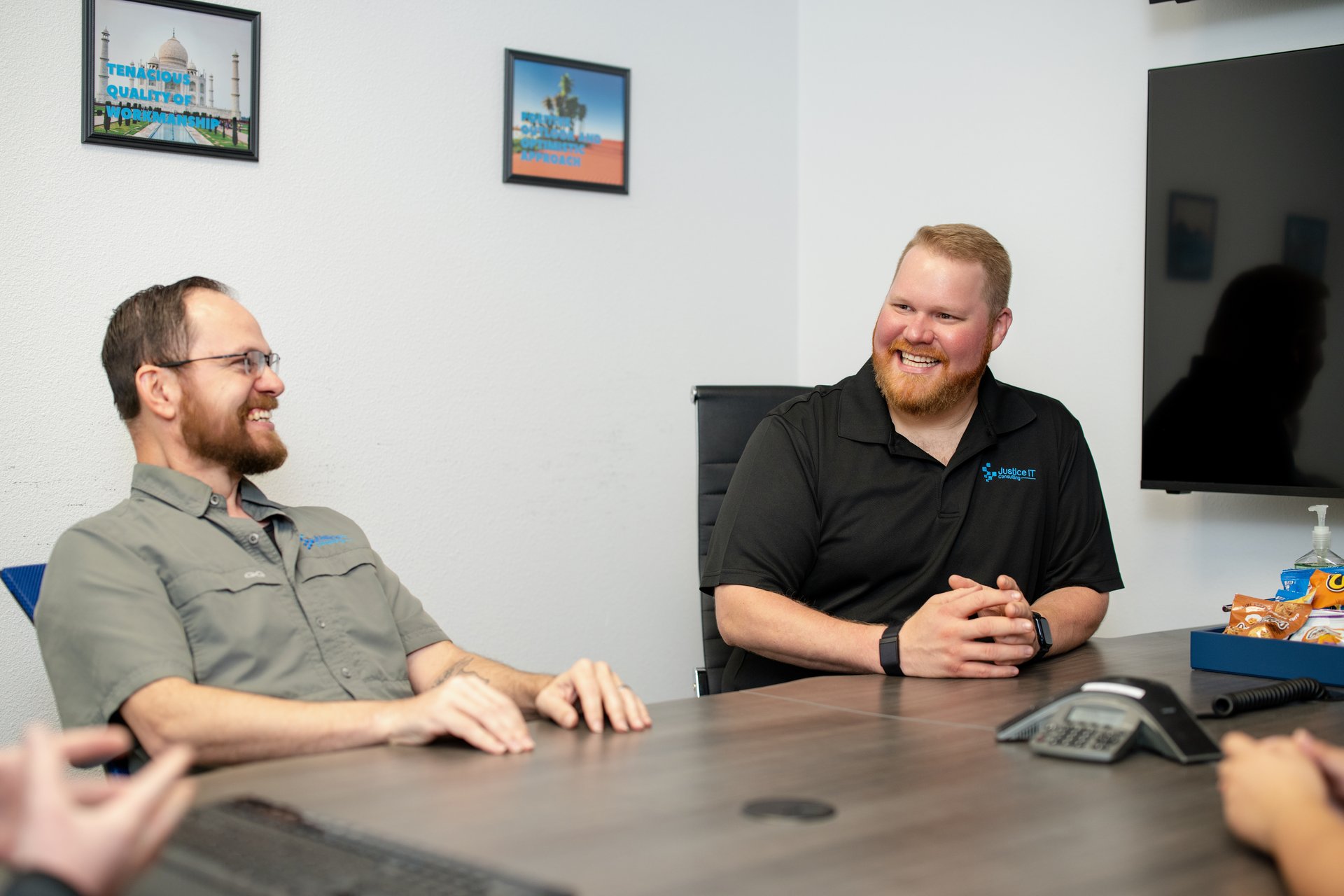 Justice IT Consulting team members talking across a conference table
